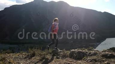 年轻的女徒步旅行者在山顶悬崖上用智能手机拍摄带有太阳耀斑效果的照片。3840x2160